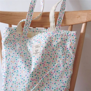 Detail view of cotton tote bag showing macaron polka dot print and fabric label on canvas