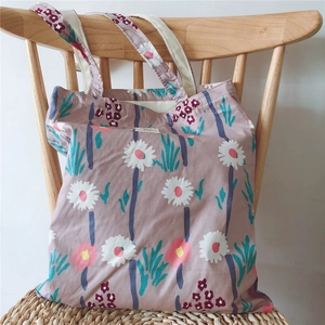 Detail of floral and leopard print canvas tote bag hanging on a wooden chair