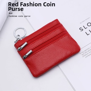 Macro shot of red pebble grain leather coin purse with triple zipper and silver keychain