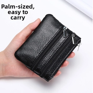 Close-up of black leather coin purse with triple zipper compartments and pebble texture
