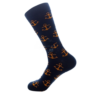 Detail of navy blue cotton crew socks featuring orange anchor patterns and ribbed cuffs