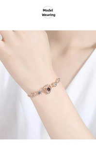 Close-up of rose gold heart link bracelet with crystal inlay and projection bead on wrist