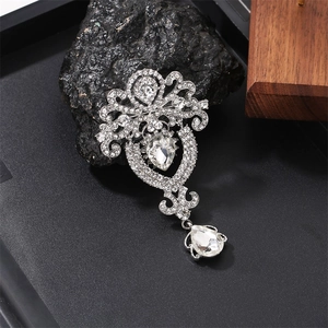 Detail view of a vintage crystal teardrop brooch with alloy rhinestones on a black stone base