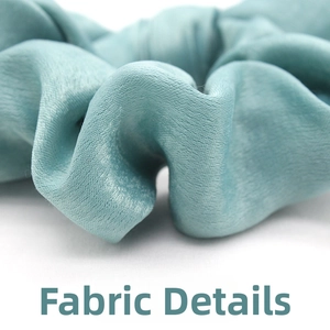 Detailed macro shot of light cyan satin scrunchie with vertical pleated texture