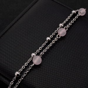 Double-layer strawberry crystal bracelet with pink beads on a textured black gift box