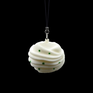 Squishy bun keychain toy with slow-rebound PU foam and green polka dots on black background