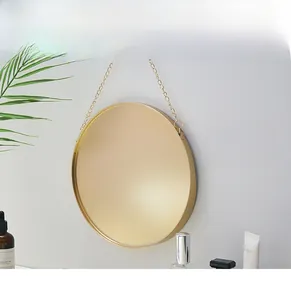 Close-up of a Nordic round gold steel mirror with a hanging chain and high-precision frame