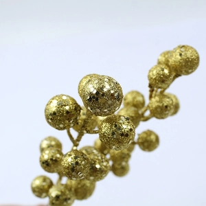 Detail of a decorative golden berry branch covered in sparkling glitter and sequins