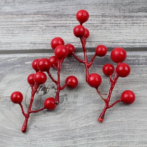 Detailed view of artificial red Christmas berries on a rustic grey wood background