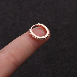 Mini rose gold hoop earring with pave zircon stones displayed on finger
