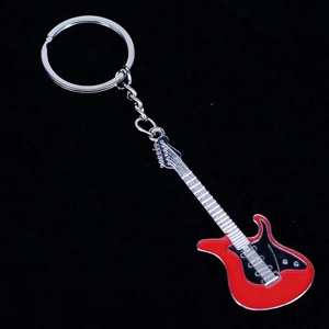 Llavero de guitarra eléctrica roja en metal sobre fondo negro, vista diagonal