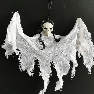 Close-up of Halloween hanging ghost with skull and white mesh fabric on dark background