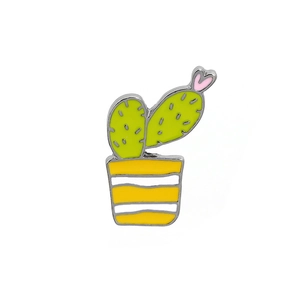 Close-up of green cactus enamel pin with pink heart detail and striped yellow pot