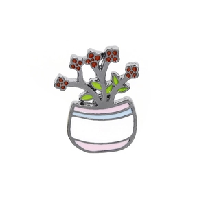 Close-up of a cartoon cactus enamel pin in a colorful pot on a white background