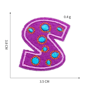 Detail of purple letter S embroidered patch with dimensions 3.8x3.5cm and orange stitching