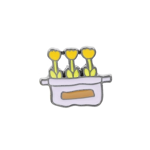 Detail of enamel pin featuring yellow tulips in light purple pot on white background