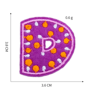 Macro detail of purple letter D embroidery patch showing size 3.8 cm x 3.6 cm dimensions