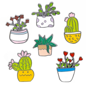 Detail shot of six enamel cactus lapel pins with vibrant green succulent plant designs