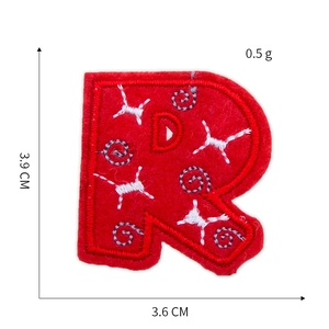 Macro detail of red letter R embroidery patch with star patterns and size markings