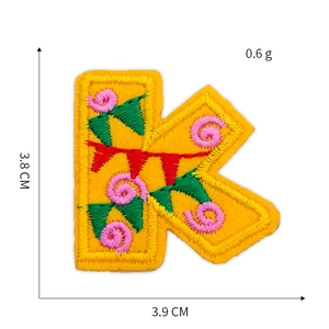 Detail of yellow letter K embroidery patch with floral patterns and dimension specs