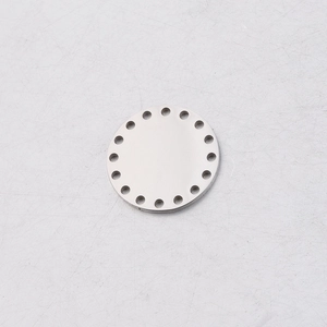 Macro detail of round mirror stainless steel pendant with multiple precise perimeter holes