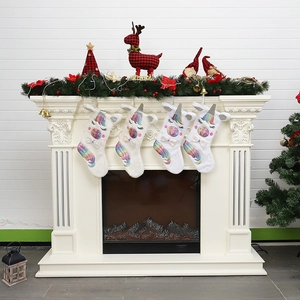 Détail de quatre chaussettes de Noël licorne en peluche blanche suspendues à la cheminée