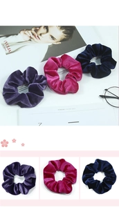 Gros plan de chouchous en velours violet, magenta et bleu marine à la texture soyeuse