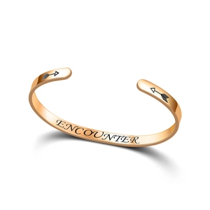 Close-up of rose gold C-shaped titanium steel bangle with 'ENCOUNTER' engraving