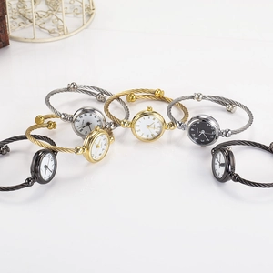 Detail view of quartz cuff watches in gold silver and black with steel wire bands