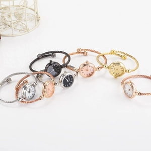 Detailed display of assorted bangle watches with metallic cable bands in multiple colors
