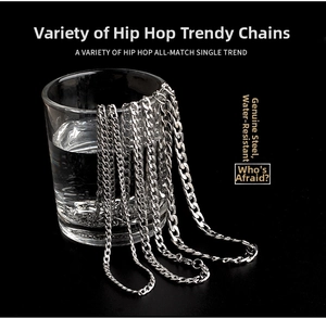 Polished silver stainless steel Cuban link chains for men hanging on a glass of water