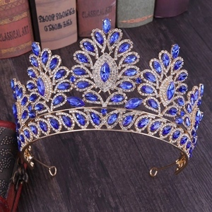 Dettaglio di corona barocca dorata con cristalli blu intenso su superficie in legno