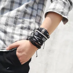 Detail of men's layered leather bracelet set with owl charm on male wrist