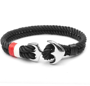 Close-up of black braided nylon cord bracelet with silver anchor buckle and red accent