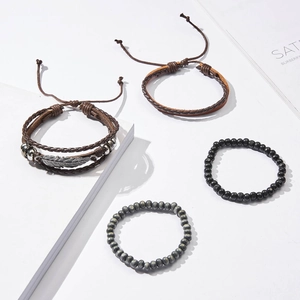 Detail of four-piece men's leather bracelet set with feather charm and wooden beads