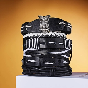 Detail of multi-layer leather bracelet set with silver owl charm and woven straps