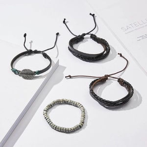 Detail of four-piece men's leather bracelet set with leaf charm and wooden beads