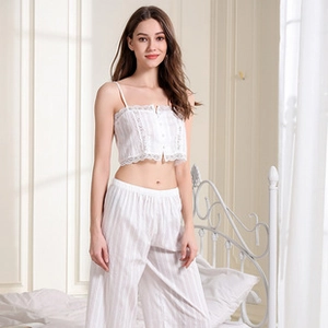 Detailed close-up of white two-piece pajama set with lace trim and vertical stripes texture