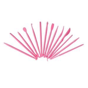 Set of 14 pink plastic cake carving tools for fondant and clay modeling on white background