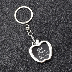 Silver apple-shaped photo frame keychain on black background, fits 3.2cm square pictures
