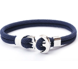 Detail of silver anchor clasp on navy blue braided rope nautical bracelet with white accents