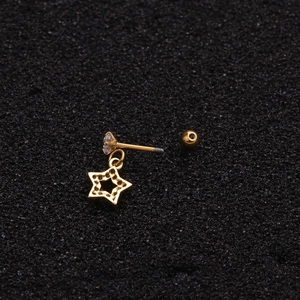 Gold star screw back stud earring with sparkling zircon on a textured dark surface