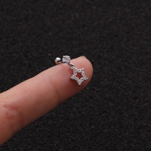 Macro detail of starfish cartilage stud earring with cubic zirconia on a finger