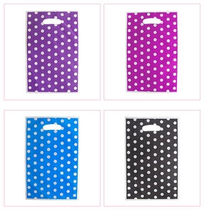 Polka dot party gift bags in purple, rose, blue, and black with die-cut handles