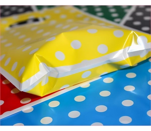 Close-up of a yellow polka dot party gift bag with self-adhesive seal for candy packaging