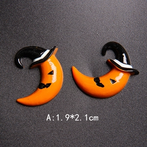 Detail of Halloween pumpkin resin accessory with size 1.9x2.1cm on dark background