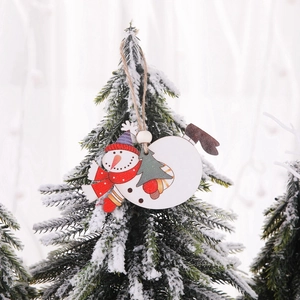Christmas snowman wooden hanging decoration on snowy pine branch for festive tree decor