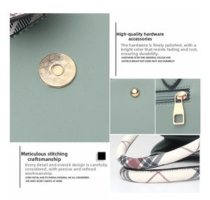 Detail of light green tote featuring gold magnetic buckle and classic plaid handle
