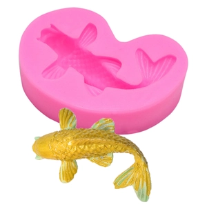Detail of pink silicone koi fish mold with a gold finished fish model for DIY baking