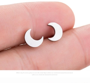 Macro detail of crescent moon stud earrings featuring a brushed silver metallic texture